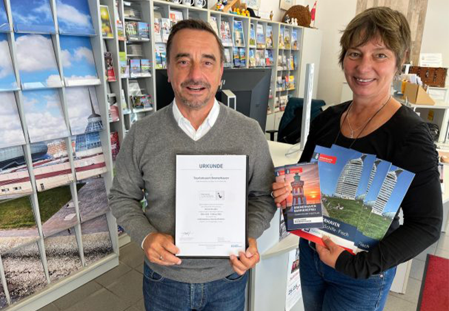 Mit dem Qualitäts-Kennzeichen „Reisen für Alle“ wurde auch die Tourist-Info ausgezeichnet. Michael Gerber erhält von Tanja Albert die Urkunde. ©Brockmann, Erlebnis Bremerhaven